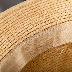 Macro detail of hand-woven straw hat showing fine texture and beige sweatband