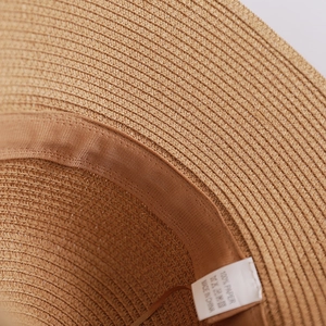 Macro detail of breathable paper straw weave and moisture-wicking sweatband inside the hat