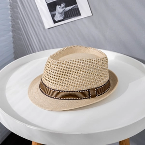 Detail of breathable straw fedora featuring striped ribbon on a white minimal table