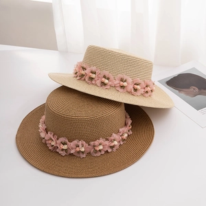 Detailed straw sun hats with floral ribbon in beige and brown for beach vacations