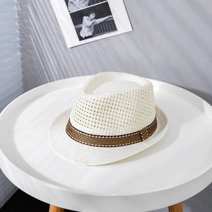 Close-up of breathable mesh hollow weave and striped ribbon on white straw fedora hat