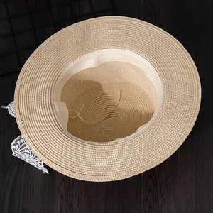 Detail view of woven straw sun hat showing interior adjustable drawstring and lace
