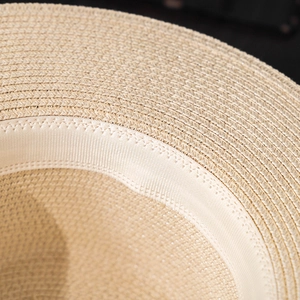 Close-up of the fine straw weaving and inner sweatband on a beige summer sun hat