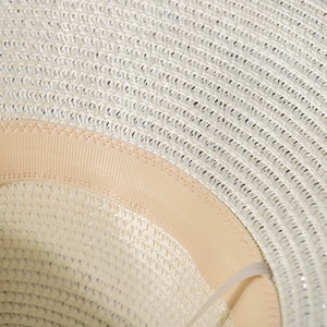 Close-up of the finely woven straw texture and internal pink satin sweatband detail