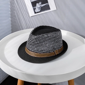 Close-up of a woven straw fedora featuring breathable black and white checkered textures