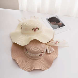 Straw sun hats with wavy brims, rose embroidery, and lace ribbons for women
