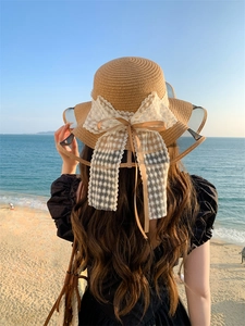 Dettaglio cappello di paglia con fiocco in pizzo a margherita e bordo in rete