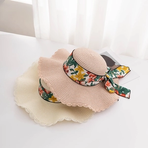 Stylish wide brim straw sun hats for women with floral ribbon bow and wavy edges for beach