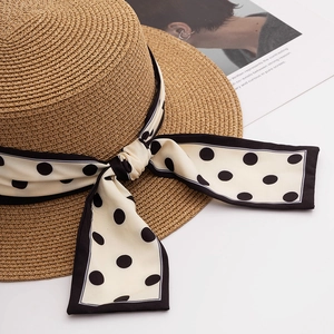 Close-up of woven straw hat texture with a black and white polka dot ribbon bow