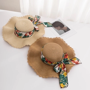 Fashionable wide brim straw sun hats with floral ribbon bow and wavy edges for beach vacations