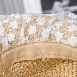 Detail of straw hat texture with white floral lace trim and inner sweatband