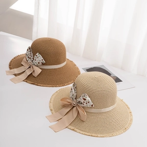 Women's summer straw sun hat with bow tie and frayed edge tassels in beige and brown