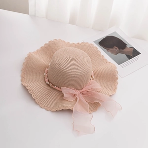 Elegant wide-brim straw sun hat with pearls and pink organza bow for beach use
