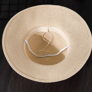 Detail of summer straw hat interior with adjustable drawstring and elastic wind rope