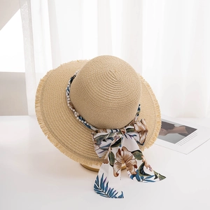 Detail of summer straw hat with pearl trim and tropical floral silk ribbon decoration