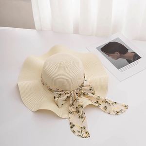 Détail d'un chapeau de paille à larges bords avec ruban élégant en mousseline fleurie