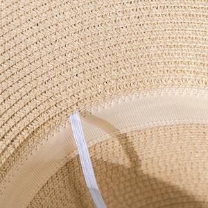 Detail of woven straw texture with inner sweatband and white elastic wind strap