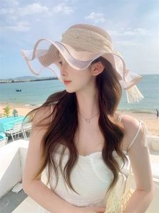 Close-up of woven sun hat featuring elegant lace trim and delicate pearl accents