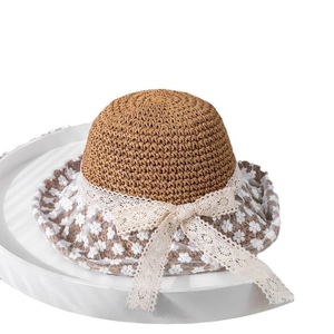 Women's summer straw sun hat featuring white floral lace embroidery and a large bow detail