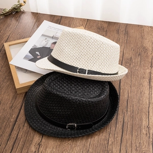 Klassischer Strohhut für Damen und Herren mit Lederband auf einem Vintage-Holztisch