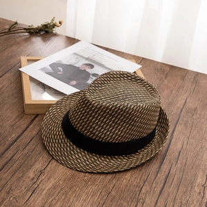 Classic straw fedora hat for men featuring a black ribbon band on a rustic wooden surface