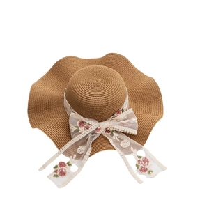 Women's woven straw sun hat with large wavy brim and embroidered floral lace ribbon