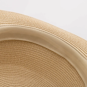 Macro view of tightly woven paper straw texture and sweatband detail on sun hat