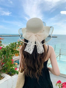Detailed back view of a straw sun hat with pearls and lace bow for women