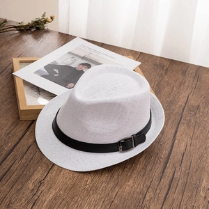 Close-up of white woven straw fedora hat featuring a black leather band and metal buckle