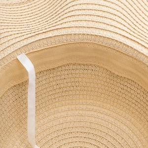 Detailed inner view of straw sun hat showing sweatband and adjustable windproof rope