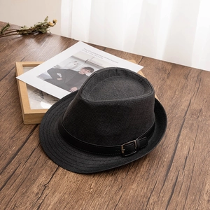 Close-up of black woven straw fedora hat featuring a stylish silver metal buckle detail