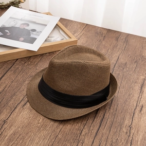Detail of breathable brown straw fedora hat featuring a classic black satin ribbon band