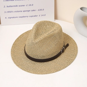 Close-up of straw fedora hat with black leather band and silver buckle on white surface