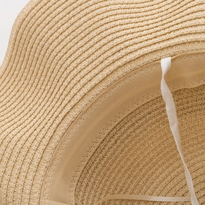 Détail d'un chapeau de paille kaki montrant le tissage dense et le bandeau intérieur