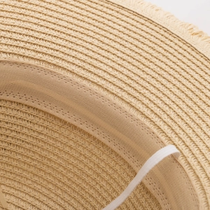 Detailed macro view of beige straw hat interior with sweatband and elastic chin strap