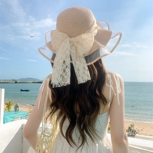 Women's straw sun hat with lace bow and pearl accents, outdoor vacation style