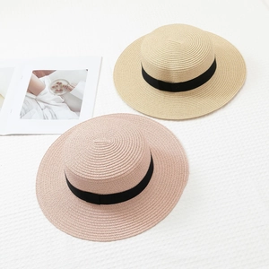 Straw flat top sun hats in beige and pink with black ribbon for beach and summer vacations