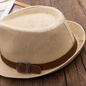 Detail of straw fedora hat featuring a brown faux leather belt and metallic buckle