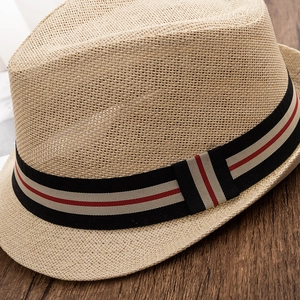 Gros plan sur un chapeau de paille tressé avec ruban tricolore et texture respirante élégante