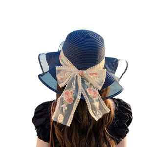 Blue woven straw sun hat with large brim, white lace bow and pink floral embroidery