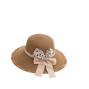 Brown woven straw sun hat for women featuring fringe edges and a floral ribbon bow