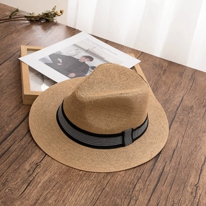 Handwoven khaki Panama straw hat with checkerboard ribbon on a dark wooden surface