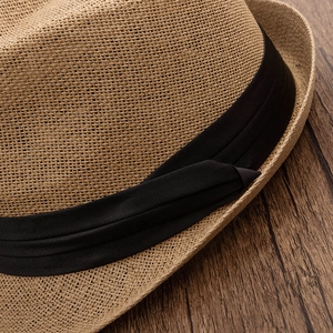 Close-up of fine woven straw texture and triple-layered black ribbon on classic fedora