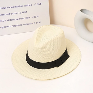 Detailed close-up of a beige straw hat with black ribbon and bow on a rustic background
