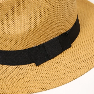 Detail of the finely woven straw hat featuring a classic black grosgrain ribbon band