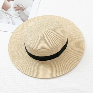 Detailed top view of light beige flat top straw boater hat with black silk ribbon trim