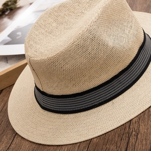 Close-up of a wide-brim straw sun hat featuring detailed weaving and a black decorative ribbon