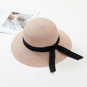 Detailed macro view of woven straw sun hat texture with black bow ribbon and wide brim