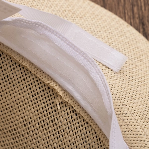 Detailed macro view of the woven straw hat interior featuring a white adjustable sweatband