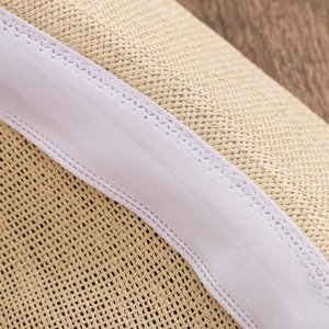 Macro shot of high-quality woven straw hat fibers with white fabric inner sweatband detail